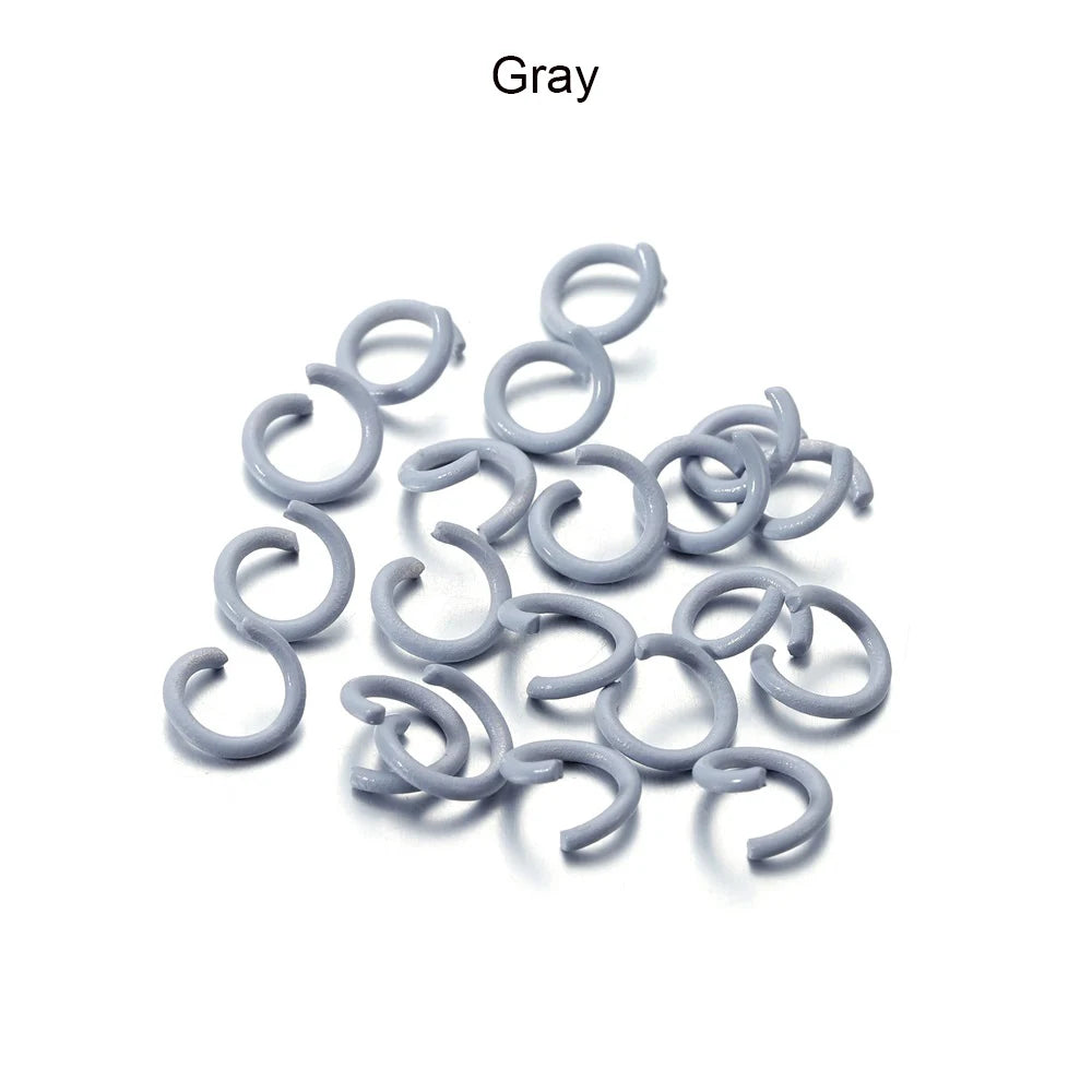 A pile of gray metal open jump rings for DIY jewelry making.
