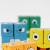 A close-up of wooden face-changing cube puzzle toys in various colors like blue, green, and yellow.