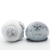 A soft, round plush toy resembling a seal in light gray and white colors.
