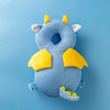 A soft blue baby head protector pillow shaped like a cow with yellow horns and ears.