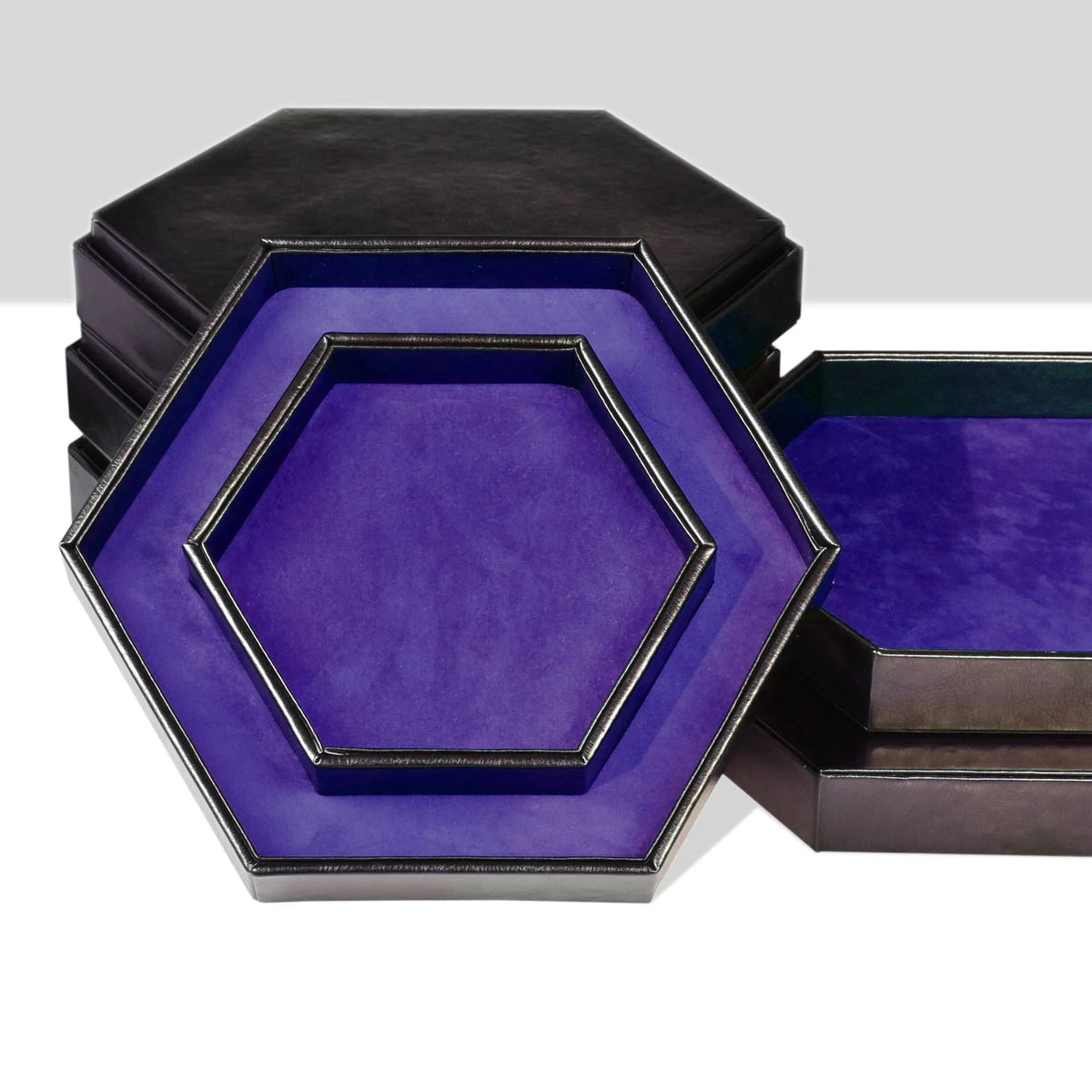 A hexagonal dice tray and storage box with a dark exterior and a vibrant purple velvet interior.