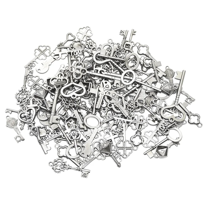 A pile of vintage metal key charms and antique keys for DIY jewelry making
