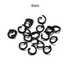 A pile of black metal open jump rings for DIY jewelry making.