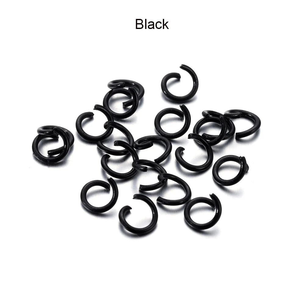 A pile of black metal open jump rings for DIY jewelry making.