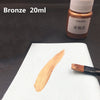 Bronze 20ml metallic acrylic paint in a glass bottle with a brushstroke on white paper