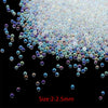 A close-up view of small, iridescent glass bubble beads scattered on a dark surface.