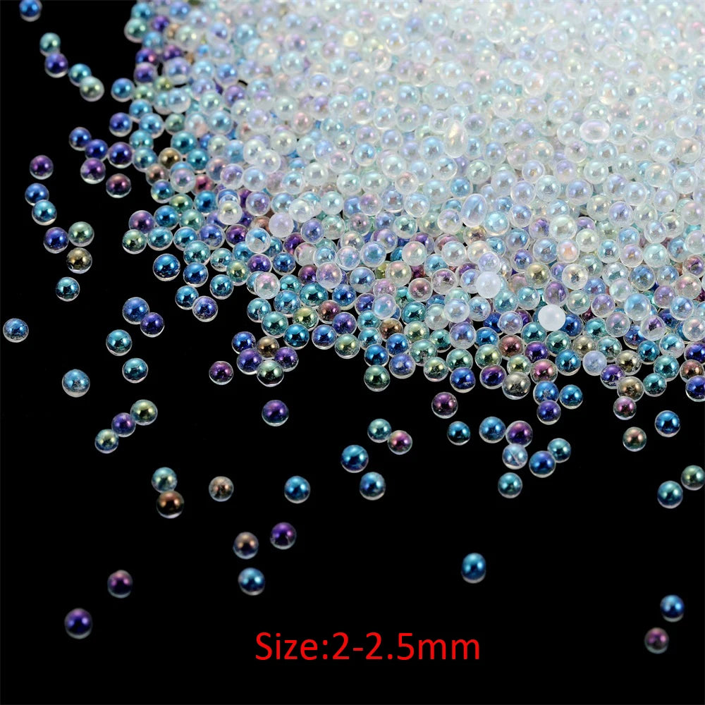 A close-up view of small, iridescent glass bubble beads scattered on a dark surface.