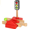A wooden train track accessory set featuring a traffic light and a gas station pump model.