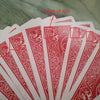 Close-up view of a deck of playing cards with red decorative patterns and marked areas labeled as the heart of Ace.