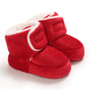 Pair of red knitted baby first walker shoes with white trim and faux fur lining