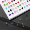 A collection of assorted acrylic stud earrings in various colors and shapes arranged on a white surface.