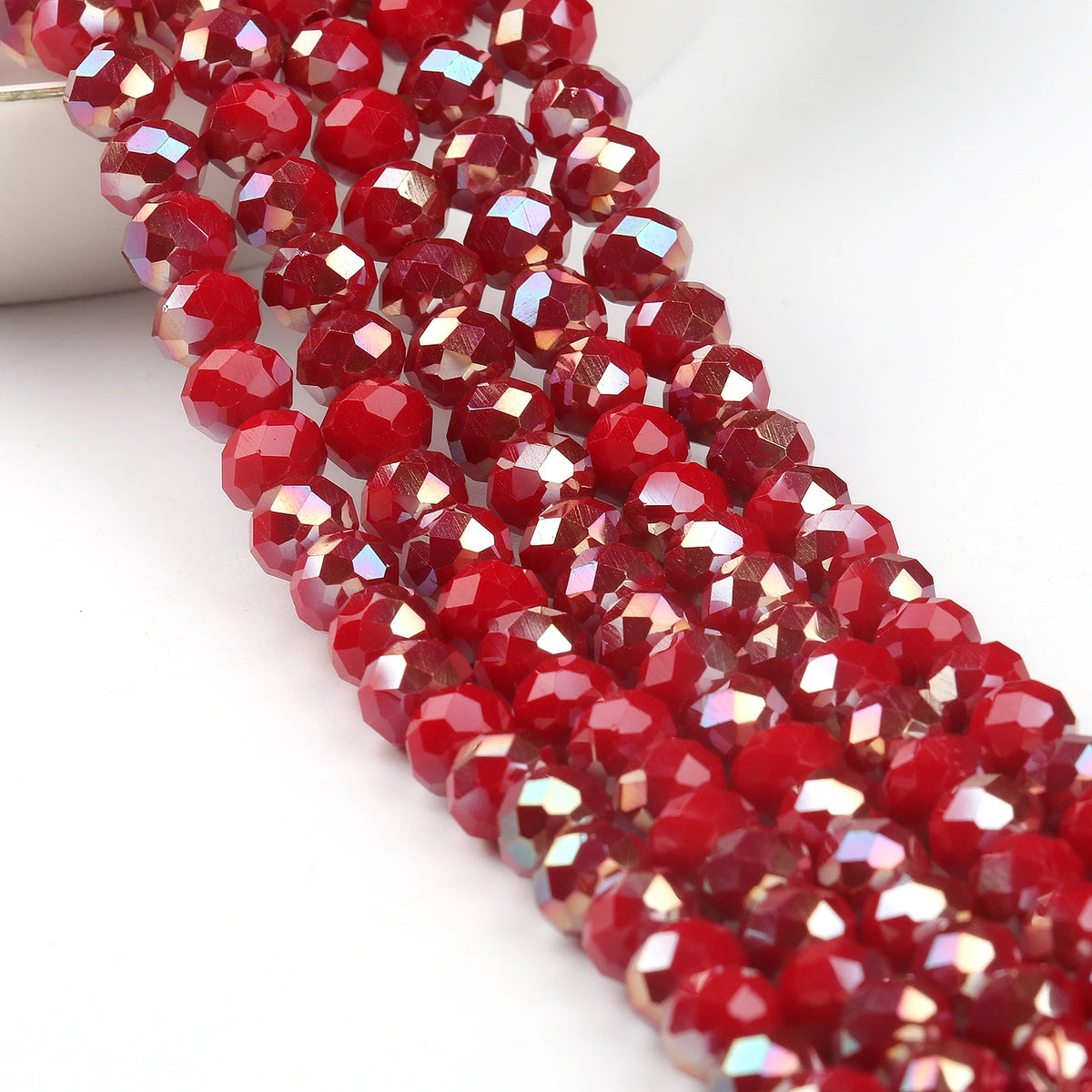 A close-up shot of red faceted crystal glass beads strung together for jewelry making