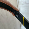 A close-up view of a brown leather strap with a black zipper attached to a black pole, likely a stroller accessory kit.