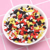 A bowl filled with multi-colored polymer clay slices in red, yellow, black, and white for slime and craft projects.