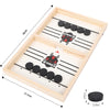 A wooden game board with two sections for a sling puck battle game featuring black pucks and winner emblems.
