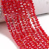 A close-up of red faceted crystal glass beads strung together, showcasing various shades of ruby and pink.