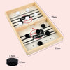 A wooden tabletop game board with black and white pucks, featuring a winner and loser designation.