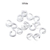 A pile of white metal open jump rings for DIY jewelry making.