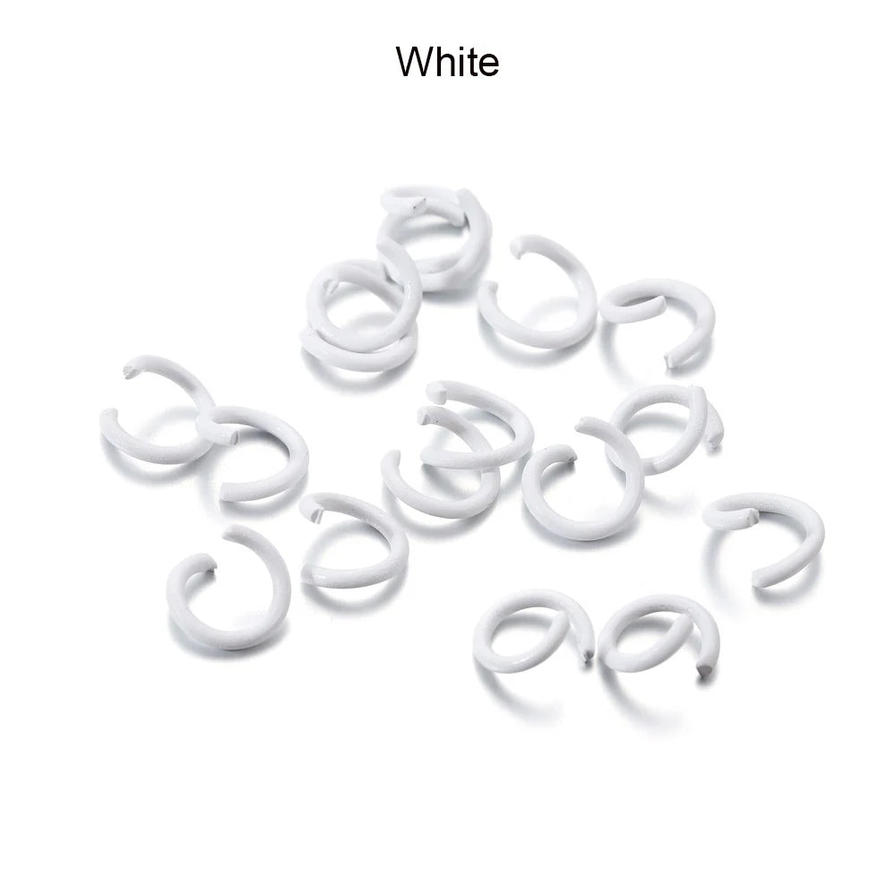 A pile of white metal open jump rings for DIY jewelry making.