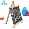 A mini wooden chalkboard easel displaying the phrase Just Fall in Love with decorative leaves.