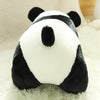 A black and white panda plush toy with soft fur resting on a white fluffy surface.