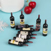 A set of miniature resin wine bottles in various colors and sizes for dollhouse decor, with a red apple in the background.