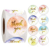 Roll of colorful round thank you stickers featuring watercolor floral designs and text