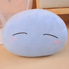 A light blue plush toy pillow shaped like a face with closed eyes and rosy cheeks.