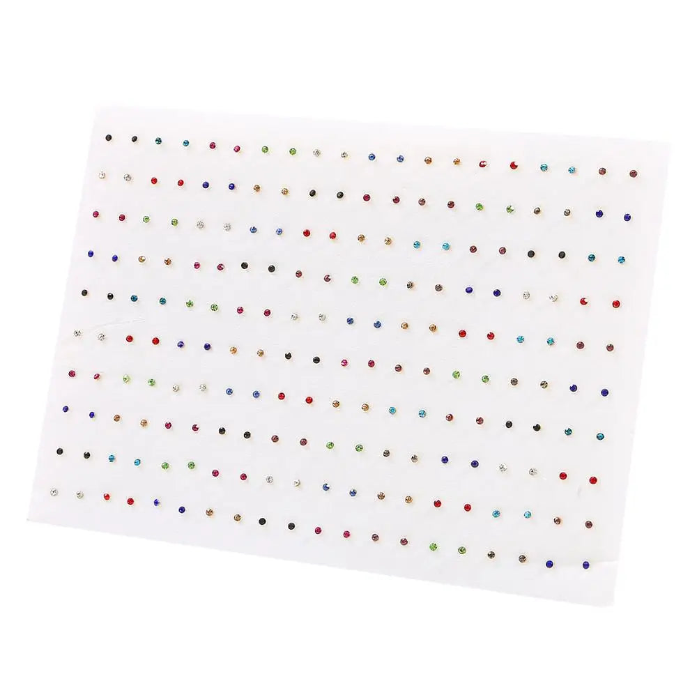 A sheet of clear plastic showing 100 pairs of assorted acrylic stud earrings including hearts, stars, and moons.