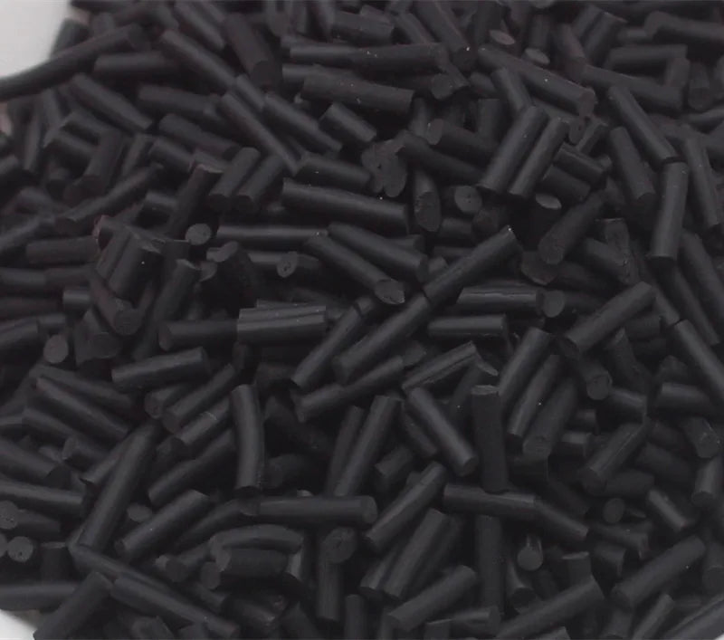 A pile of black, cylindrical soft polymer clay candy sprinkles for cake decorating.