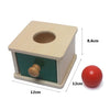 A wooden sensory toy set featuring a box with a hole and a red ball.