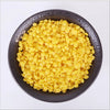 A bowl filled with yellow natural beeswax pellets for DIY candle making and skincare.
