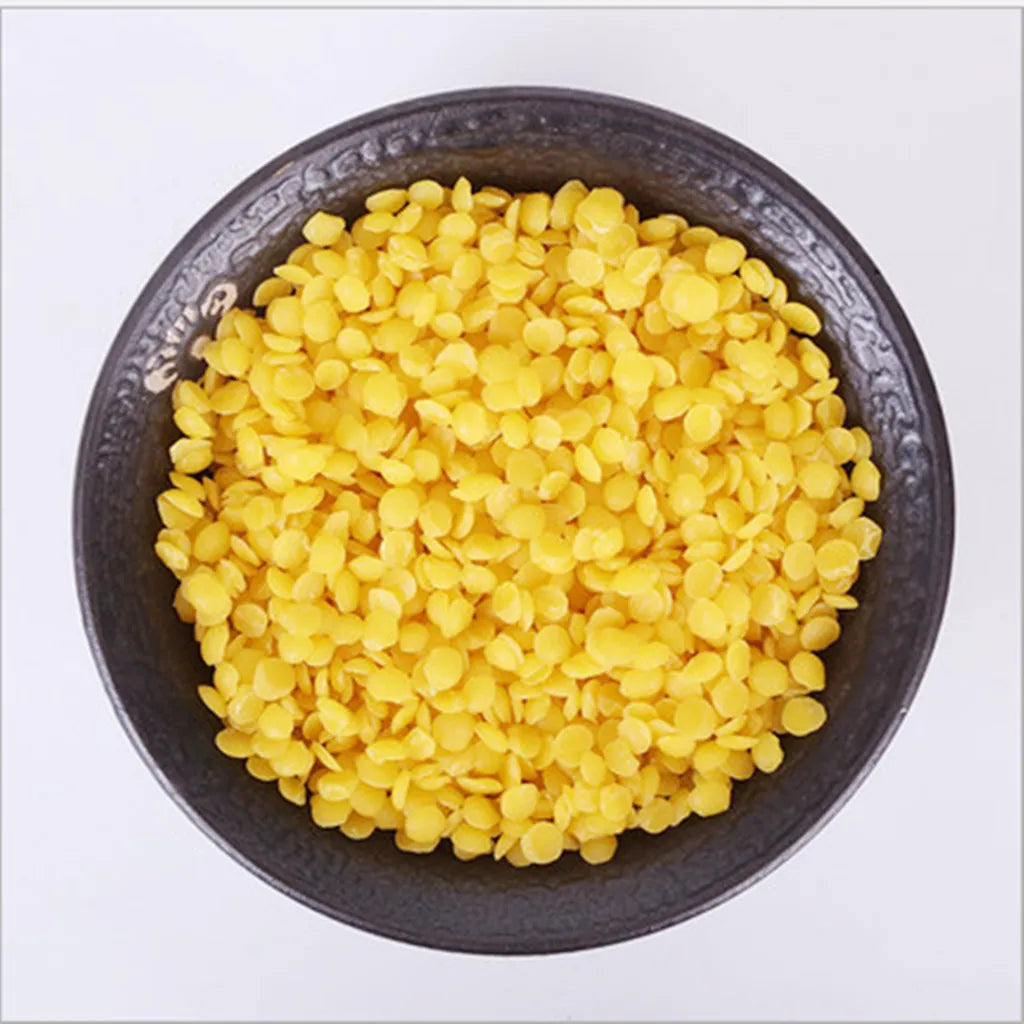 A bowl filled with yellow natural beeswax pellets for DIY candle making and skincare.