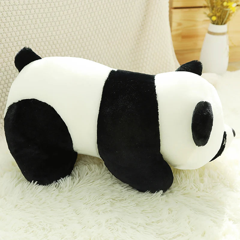 A black and white panda plush toy resting on a white fluffy surface.