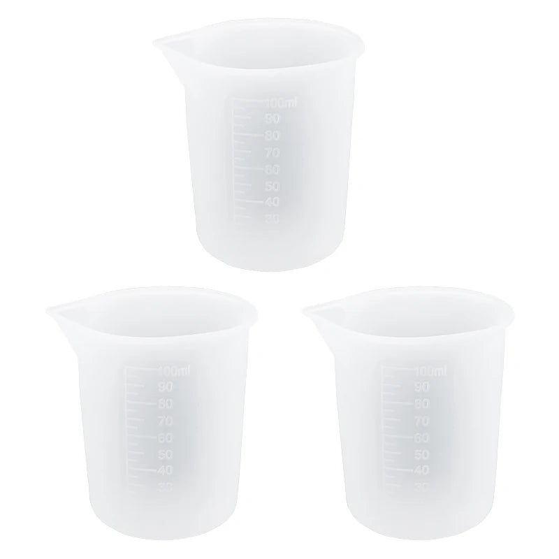 A set of clear reusable silicone resin mixing tools including measuring cups and stir sticks.