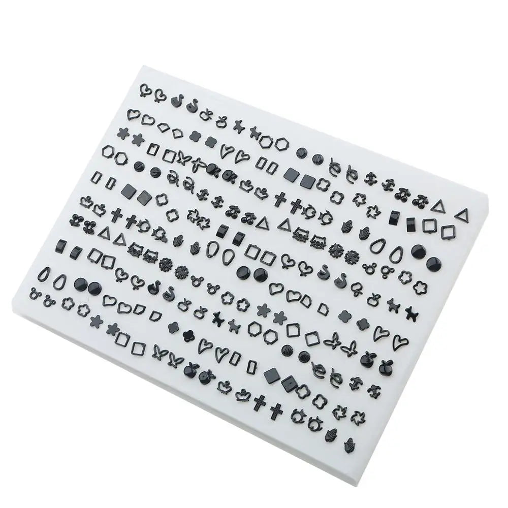 A white plastic tray filled with assorted acrylic stud earrings including hearts, stars, and moons.