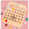 A wooden daily calendar board showing the month of April with numbered days and various small icons for learning.