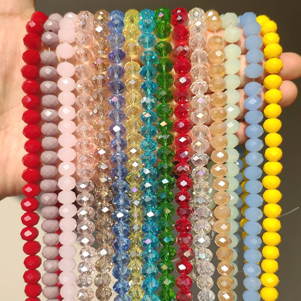 A collection of colorful faceted crystal glass beads in various shades of pink, blue, green, and yellow strung together for j
