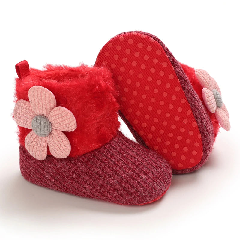 A pair of red plush baby snow boots with pink floral accents and anti-slip soles.