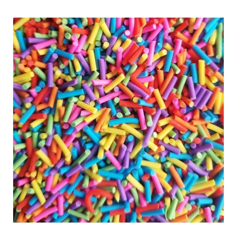 A close-up of colorful soft polymer clay candy sprinkles scattered across a surface.