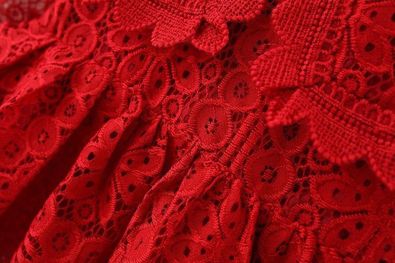 Close-up of a red lace princess dress featuring intricate floral patterns and a doll collar.