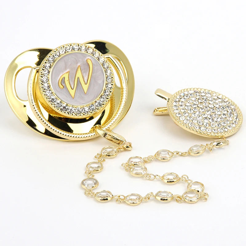 Gold rhinestone pacifier featuring a personalized initial W on a clear background with a clip.