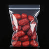 A clear resealable plastic bag filled with dried red fruit, likely jujubes or similar items.