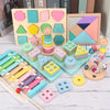 A collection of colorful wooden Montessori sensory blocks and a music rattle arranged on a white surface.