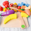 A set of magnetic wooden fruit and vegetable cutting toys in various colors and shapes on a light wooden board.
