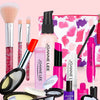 A collection of makeup brushes, lipsticks, and palettes displayed next to a pink patterned handbag.