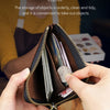 A hand holds a brown leather coin purse with a zipper open, showing various coins and cards inside.