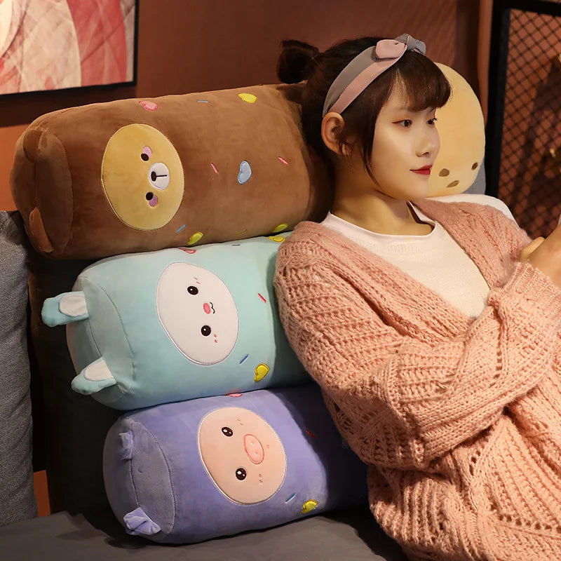 A woman is holding a pink knitted sweater and several cute, long body stuffed animal plush pillows.