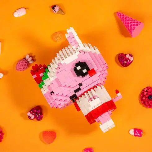A pink and black Lego-style figure resembling a rabbit is constructed from various colored building blocks on an orange backg
