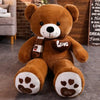 A brown plush teddy bear with a white face and black nose, wearing a striped knit scarf.